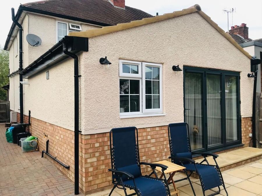 Rendered rear extension with anthracite bifold doors and a brick plinth